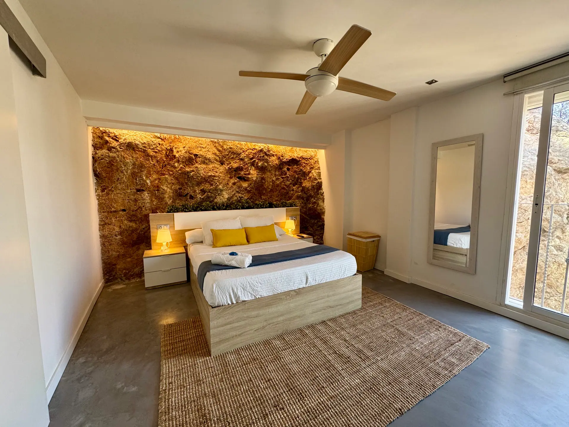Dormitorio de Villa Cap Blanc con pared de roca natural iluminada