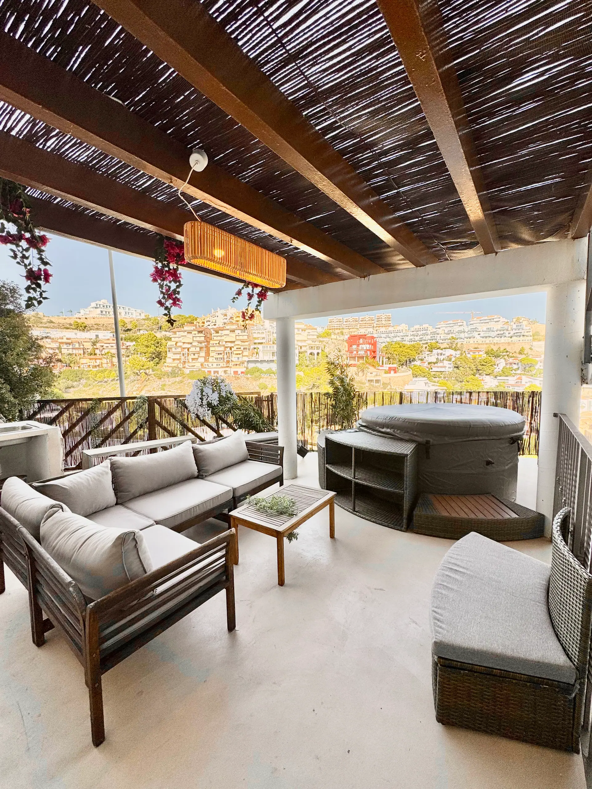 Terraza cubierta con jacuzzi y sofás de exterior